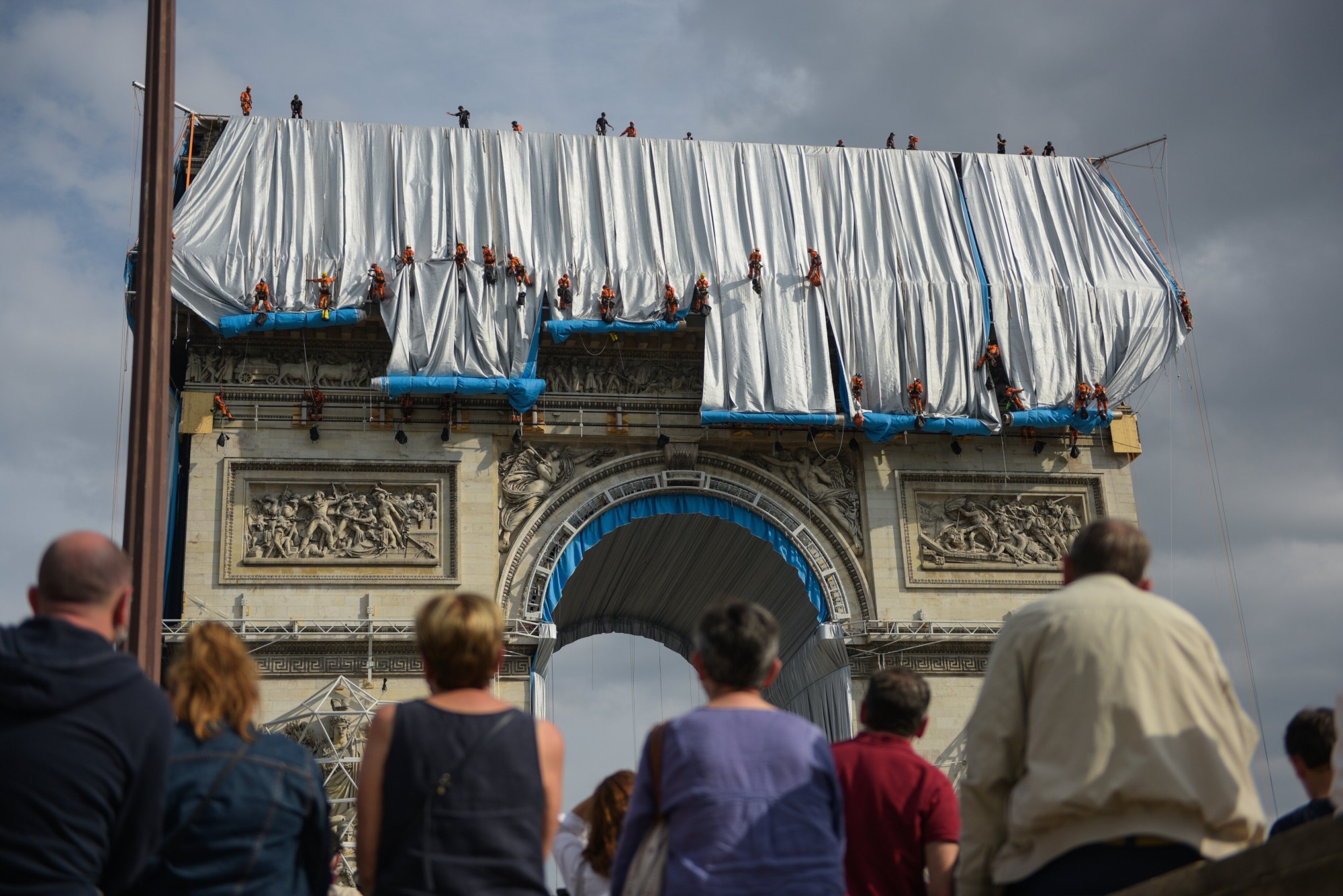 Fabric panels are unfurled in front of the outer walls of the Arc de Triomphe Benjamin Loyseau © 2021 Christo and Jeanne-Claude Foundation title=